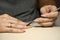 Woman doing manicure for herself with cuticle stainless stick.