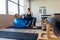 Woman doing pilates workout on a fitness ball at a gym