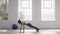 Woman doing plank with alternating leg lifts at fitness studio