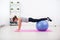 Woman doing push-ups on the floor with fit ball in