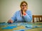 Woman doing puzzle in quiet house with a blue dressing gown