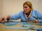 Woman doing puzzle in quiet house with a blue dressing gown