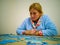 Woman doing puzzle in quiet house with a blue dressing gown