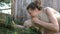 Woman doing selfie on smartphone with white lamb on farm, little lamb chewing grass