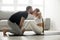 Woman doing sit-ups exercise kissing man, couple workout at home