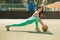 Woman doing stretching exercise on ball. Fitness female exercising on street