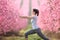 Woman doing tai chi exercise in a pink flowered field