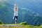 Woman doing yoga asana tree pose outdoors