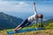 Woman doing yoga asana Vasisthasana - side plank pose outdoors