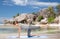 Woman doing yoga in balancing table pose on beach