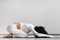 A woman doing yoga on a mat, kneeling makes a bow stretching her arms forward in the gym