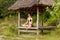 Woman doing yoga meditation in tropical gazebo