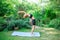 Woman doing yoga in the park, young girl doing various wellness exercises