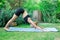 Woman doing yoga in the park, young girl doing various wellness exercises