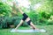 Woman doing yoga in the park, young girl doing various wellness exercises