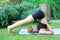 Woman doing yoga in the park, young girl doing various wellness exercises