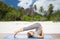 Woman doing yoga in plow pose on beach