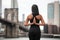 Woman doing yoga pose with arms on the back in New York City park. Yoga classes concept..