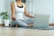 Woman doing yoga practice relaxation Women wearing exercise clothes, follow yoga clips through a laptop in the house. Concepts of