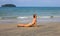 Woman doing yoga on sand beach. Tropical seaside vacation activity. Young girl in asana posture.