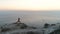 Woman is doing yoga on the top of mountain with sea view at sunset. Aerial footage. Side view.