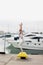 Woman doing Yoga Utkatasana pose on the stones near marine deck