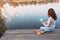 Woman drawing with soft pastels on wooden pier near water