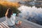 Woman drawing with soft pastels on wooden pier near water, back view