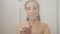 Woman draws heart on the misted glass in the shower cabin