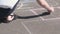 Woman draws a hopscotch on the asphalt with colorful chalks.