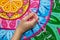 Woman draws a mandala, hand with a brush close-up