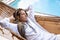 Woman with dreadlocks thinking lying in a woven hammock