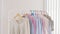 Woman dress and cloths hanging on hanger soft and pastel color in modern boutique. Colorful of collection of woman cloth hanging