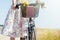 Woman in dress with flowers carries wild flowers bouquet on bicycle in basket