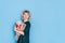 Woman in dress holding beautiful bouquet of flowers in front of blue background. Holiday gift valentine day, 14 february, March 8