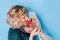 Woman in dress holding beautiful bouquet of flowers in front of blue background. Holiday gift valentine day, 14 february, March 8