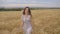Woman in dress on summer wheat field, sunset