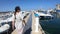 Woman in dress walking in a Mediterranean harbor with many pleasure boat, France