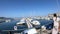 Woman in dress walking in a Mediterranean harbor with many pleasure boat, France