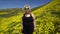 Woman dressed as an alien stands in a field of wildflowers, curious about the camera. Concept for space invaders, spooky, creepy g