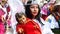 Woman dressed as angel carries baby Jesus doll, Ecuador