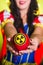 Woman dressed as fairytale character holds Radioactive atomic nuclear ionizing radiation danger warning symbol on apple