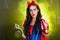 Woman dressed as fairytale character holds Radioactive atomic nuclear ionizing radiation danger warning symbol on apple