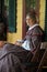 Woman dressed as wife of Ulysses S.Grant sitting on porch of Grant Cottage,New York,2014