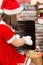 Woman dressed costume Santa Claus by fireplace. Christmas