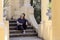 Woman dressed in hip-hop style sits on the steps among the columns in the park