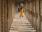 Woman dressed in orange walk in the middle of temple pillars in Virupaksha Temple in hampi karnakata