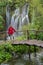 Woman dressed in red jacket in Plitvice lakes park