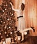 Woman dressing Christmas tree.