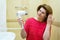 Woman dries hair a hair dryer in a bathroom